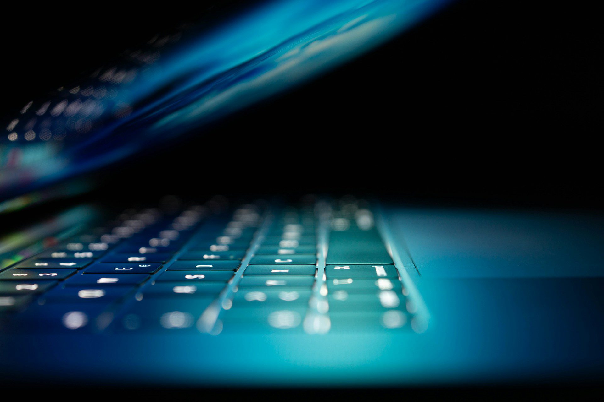 Slightly ajar laptop with blue-green haze