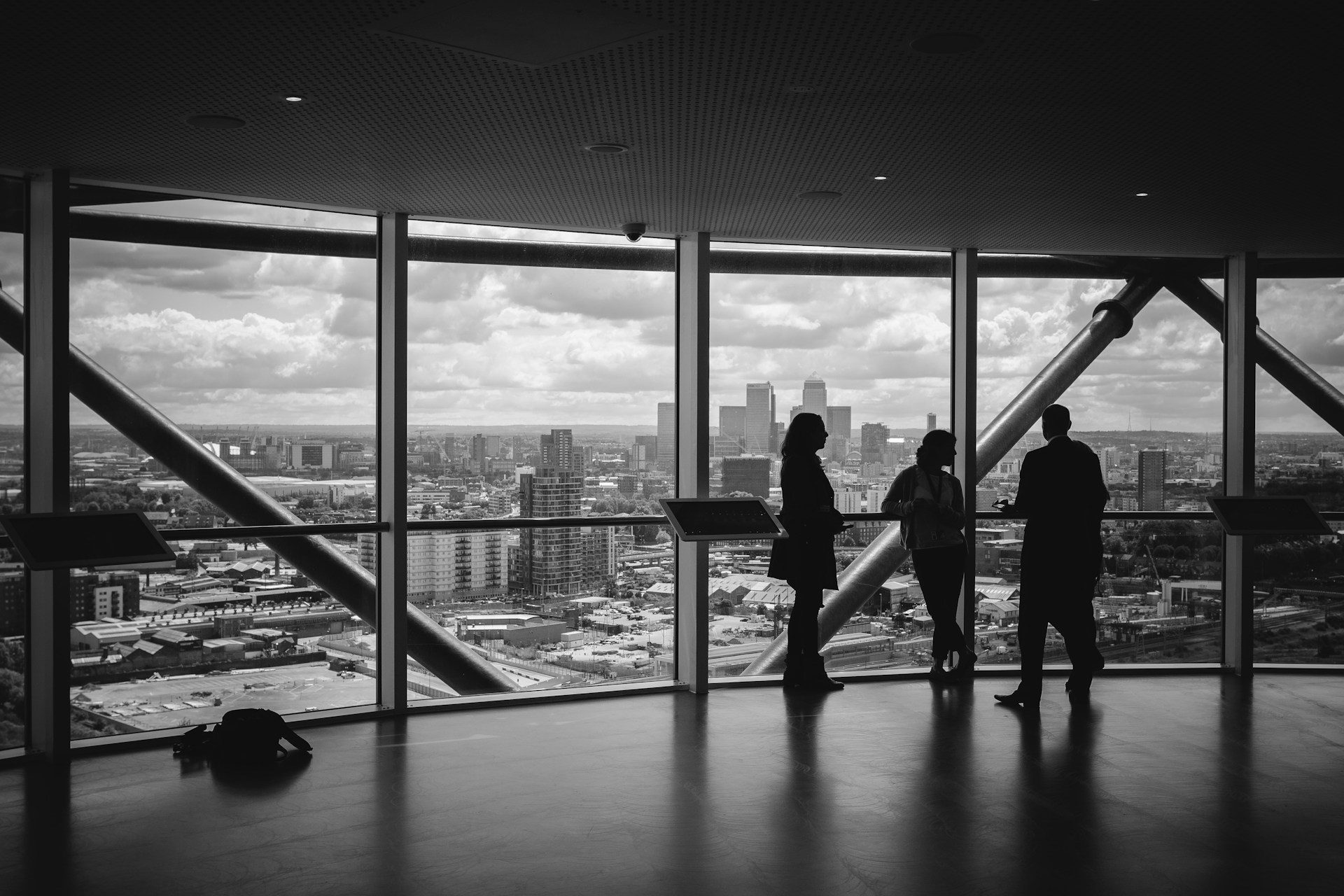 Moody office scene – large window with three people on the right hand side, all standing