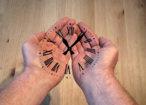 A pair of hands with a clock face projected onto them, signifying the importance of taking your time when sourcing a premium domain name.