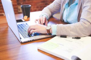 Close-up image of a person at a laptop, symbolising the importance of research when sourcing a premium domain name with help from a broker.