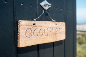 Wooden 'occupied' sign on blue door