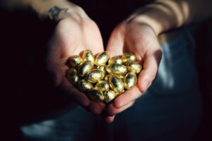 Man holds handfull of golden eggs