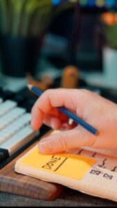 Close up of a hand above a sketch pad with a yellow post-it saying 'Done' on it.