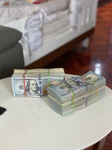 Two rolls of dollar bills on white table to denote high cost of premium domain names