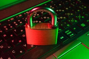 Padlock bathed in red light on a computer keyboard to denote data security