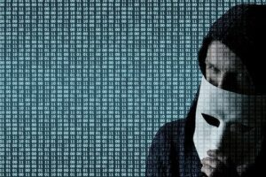 Matrix of computer text with the image of a man in a mask of the 'anonymous' style to denote security concerns with domain names