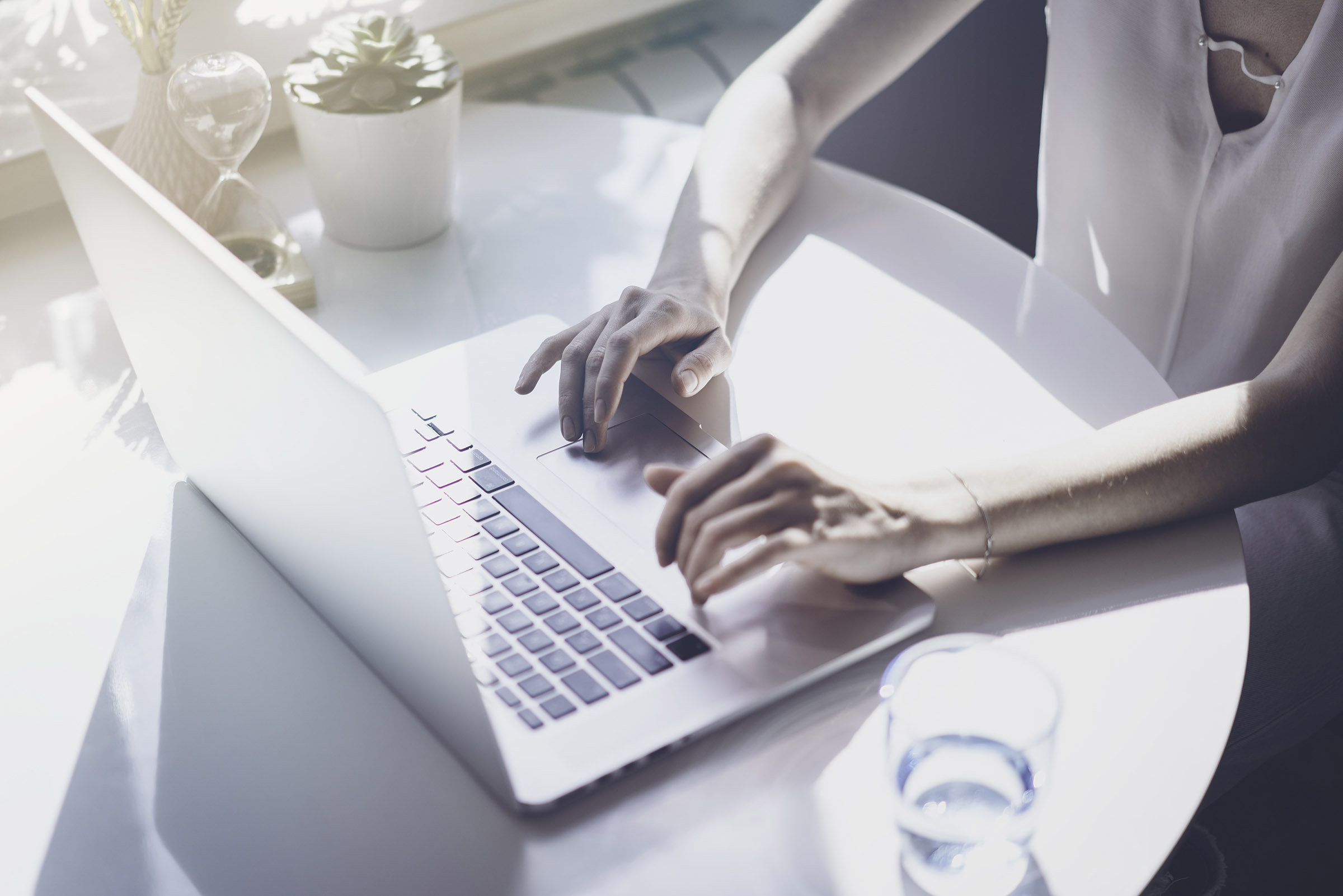 Woman's hands tapping at a laptop keyboard for article about 'parked' domain names