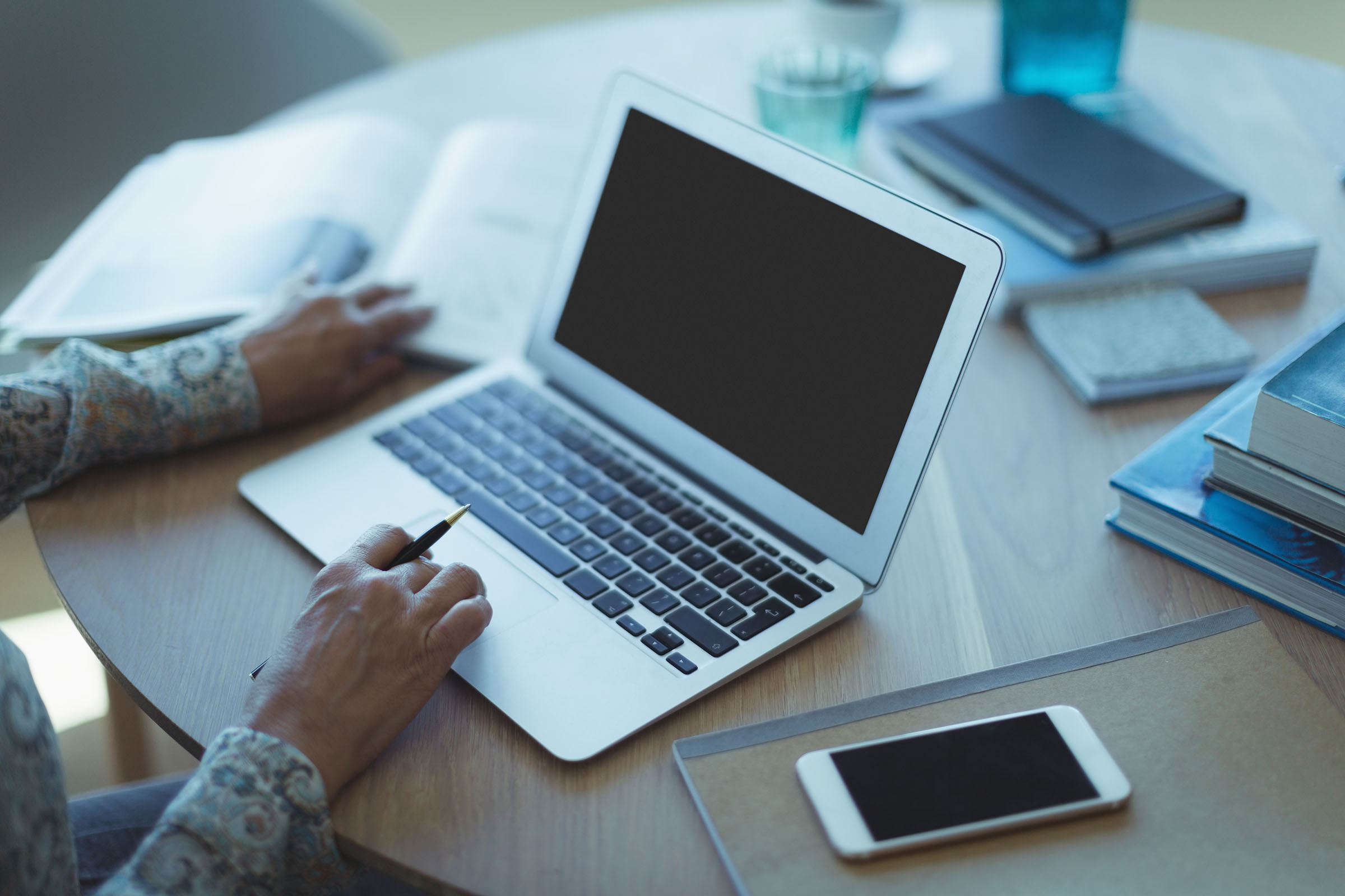 Two hands at a laptop, as if researching premium domain names